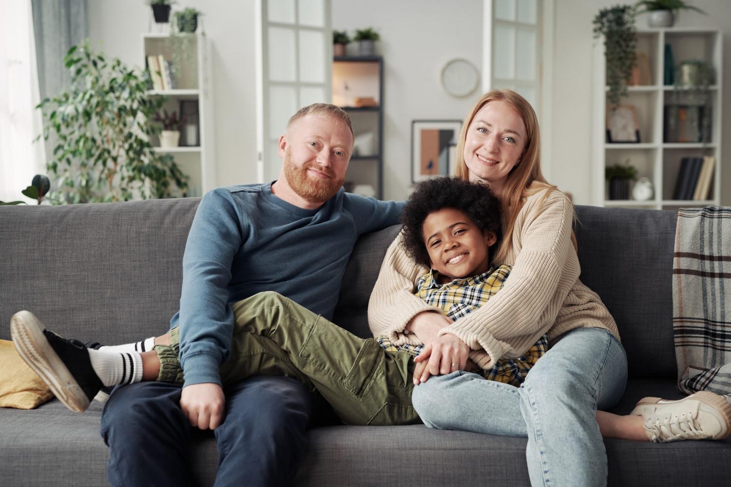 happy boy with his parents sitting on a couch